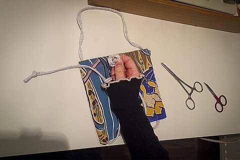 Anschließend wird das Band eingefädelt. Ich verwende hierfür eine Peanklemme. Durch ihre schlanke Form, komme ich einfach durch die Tunnel. Die Enden des Bandes werden verknotet und als Letztes wird der Draht eingefädelt.