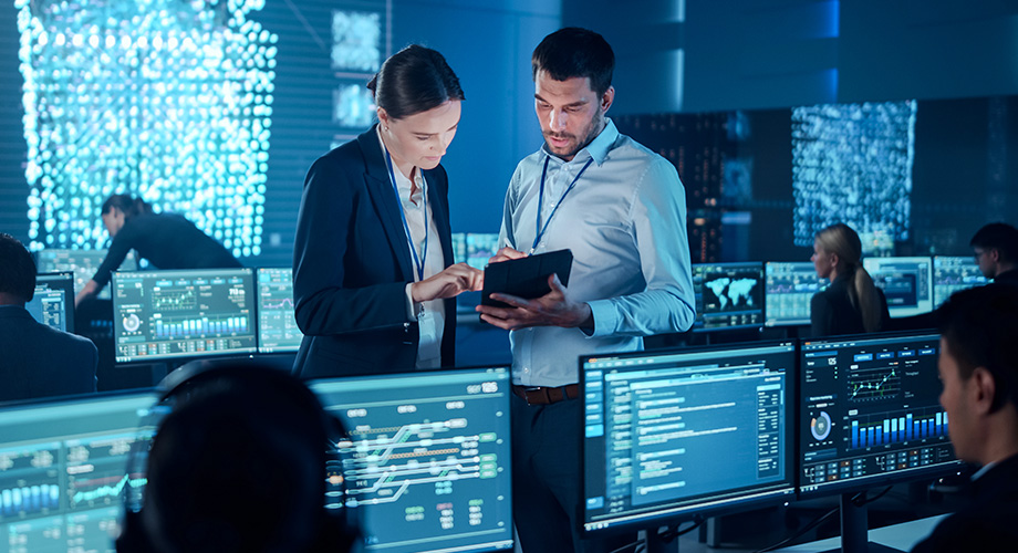 Zwei Analysten unterhalten sich in einem SOC.