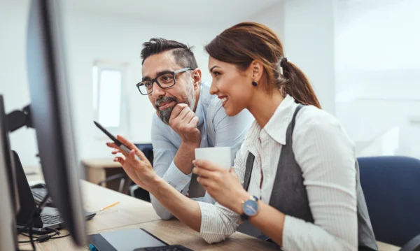Man and woman discussing something on screen