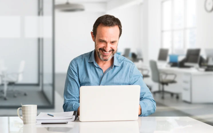 Mann schaut auf Laptop