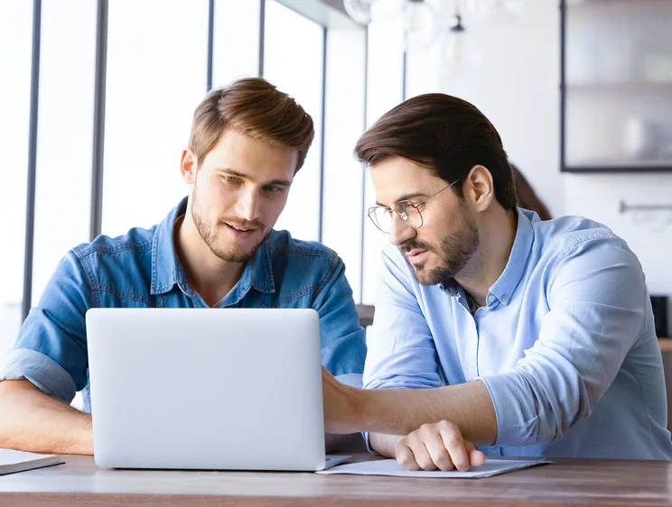 Zwei Männer vor Laptop