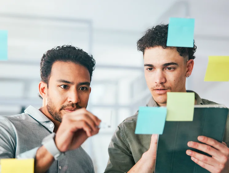 Zwei Mitarbeitende sammeln Post-its